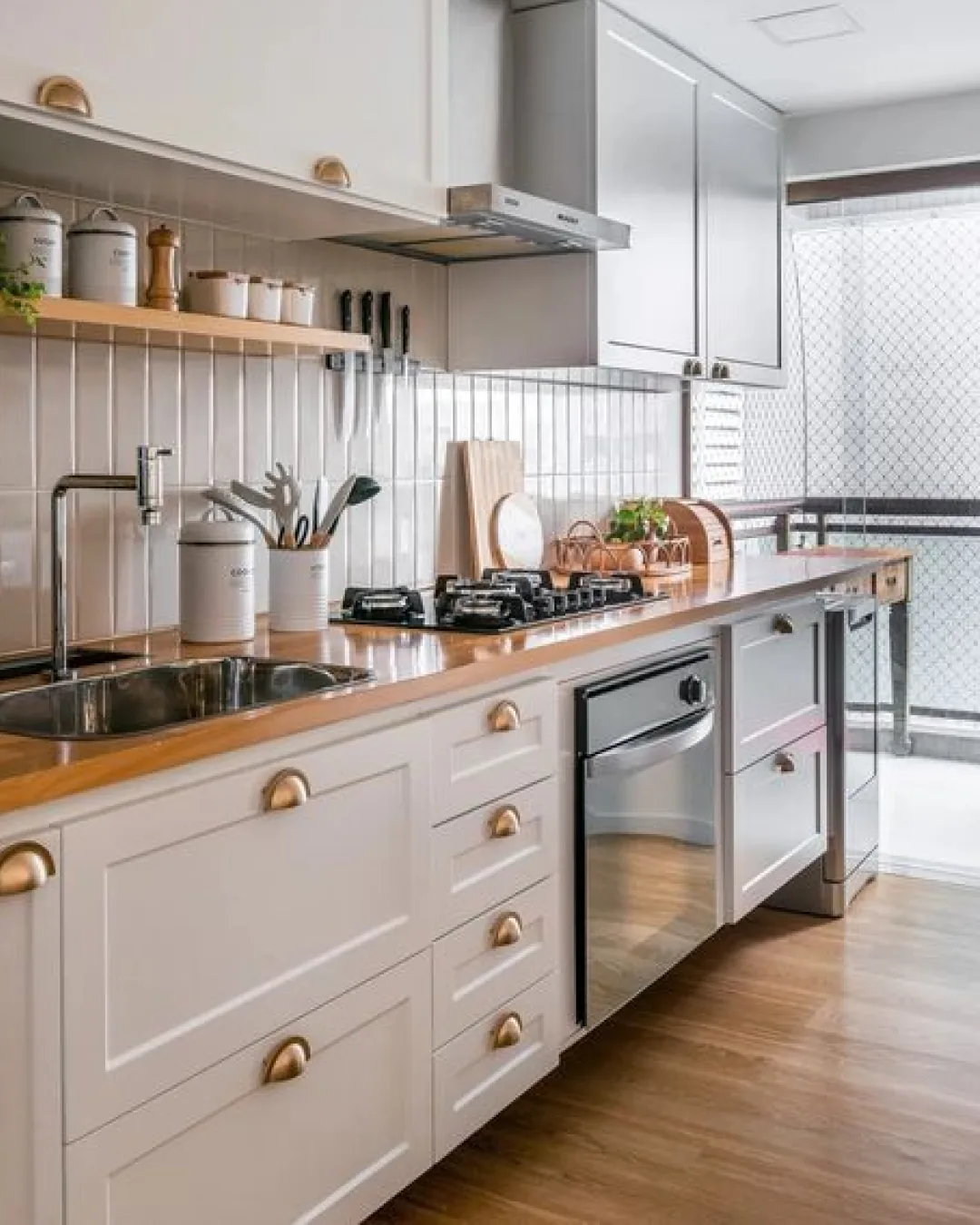 Orderly modern kitchen with clean cabinetry, cooktop, and stainless-steel appliances